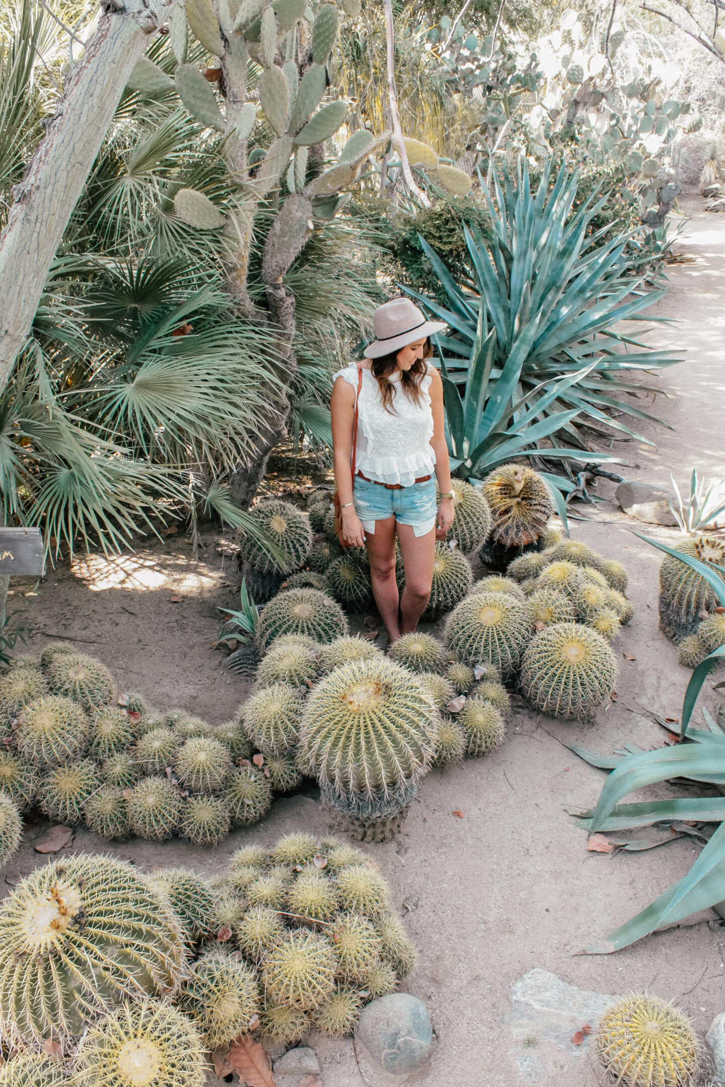 A girl stands at Moorten Botanical Garden, a fun thing to do in palm springs