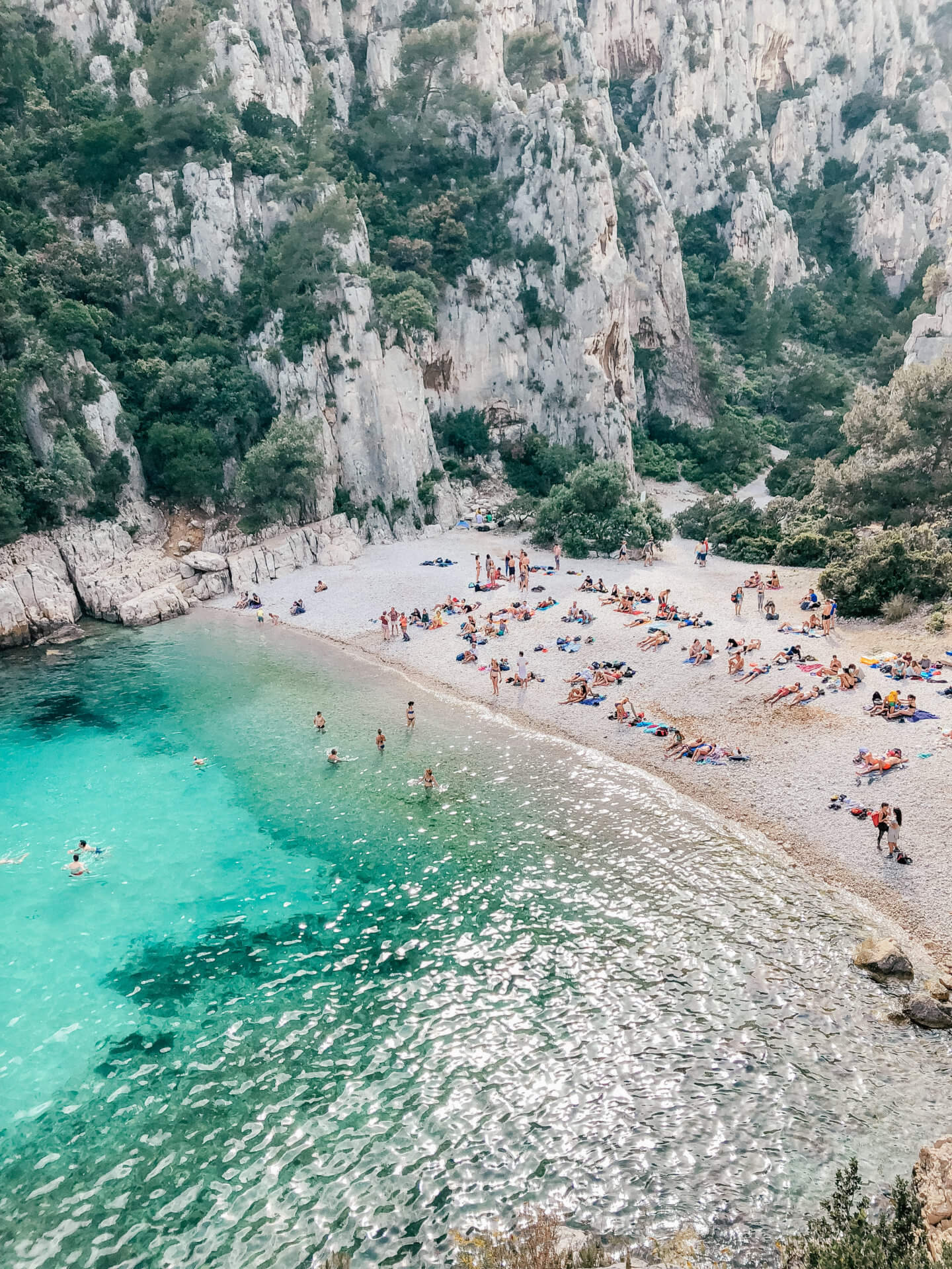 Aerial shot of sun bathers enjoying Calanque d’En Vau in Calanques National Park 