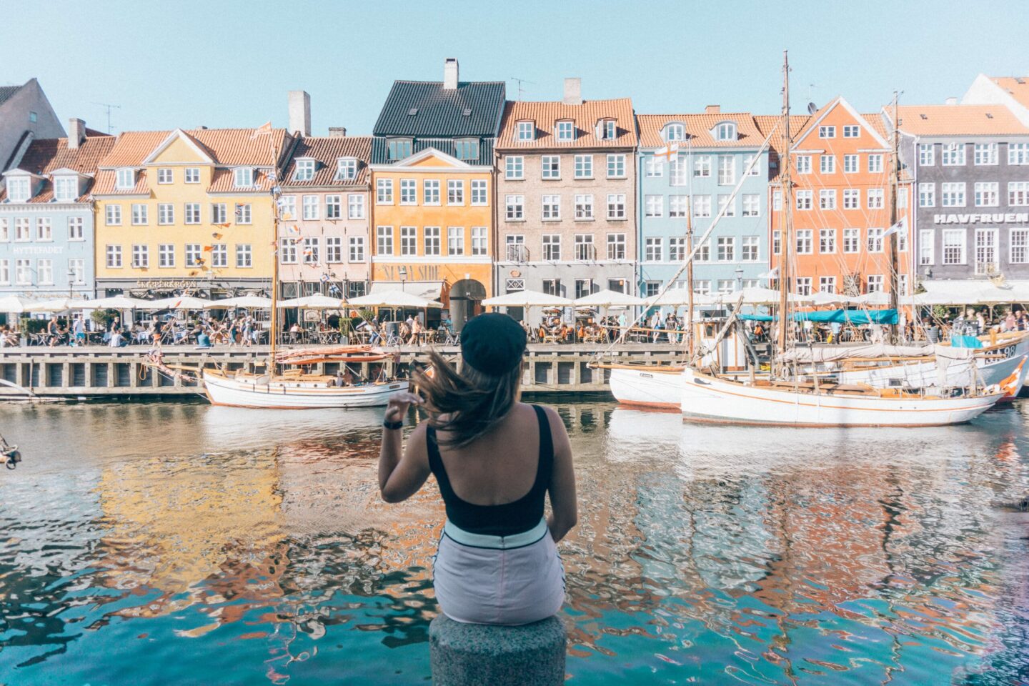 A girl flips her hair in Copenhagen, Denmark, near the colourful houses on the canals. This city is easily one of the Most Romantic Places in Europe