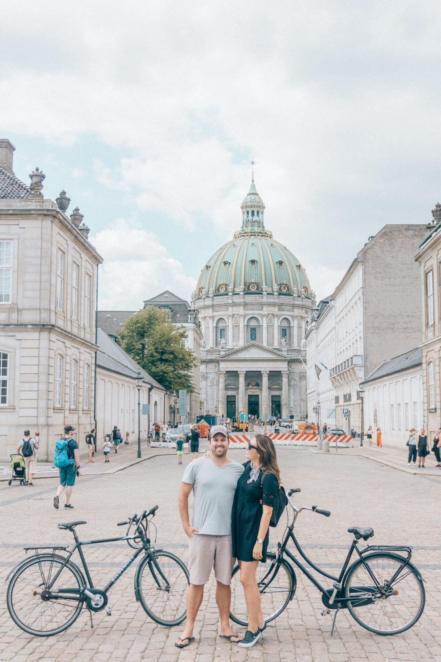 A couple with bikes standing in front of the Copenhagen domed Church