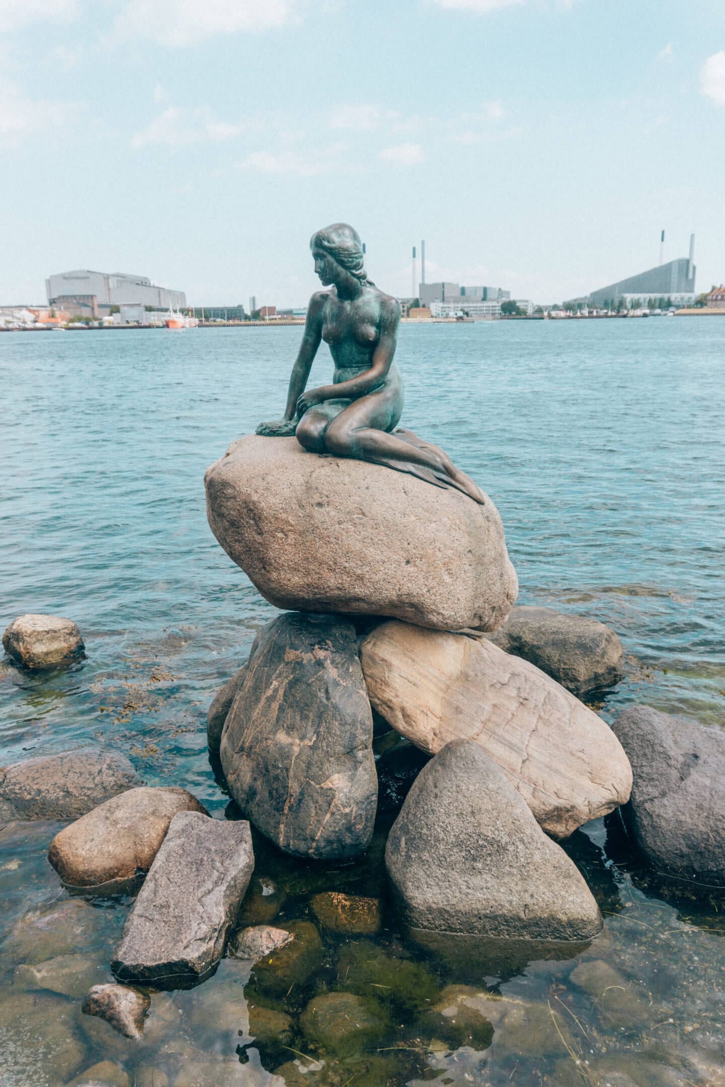 The Little Mermaid Statue on a sunny blue sky day in Copenhagen 