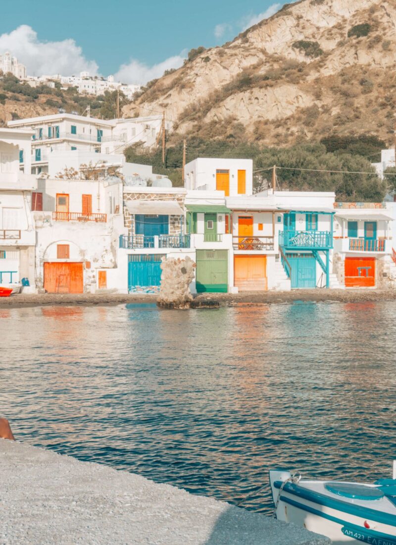 Girl sitting in front of the colourful houses of Klima