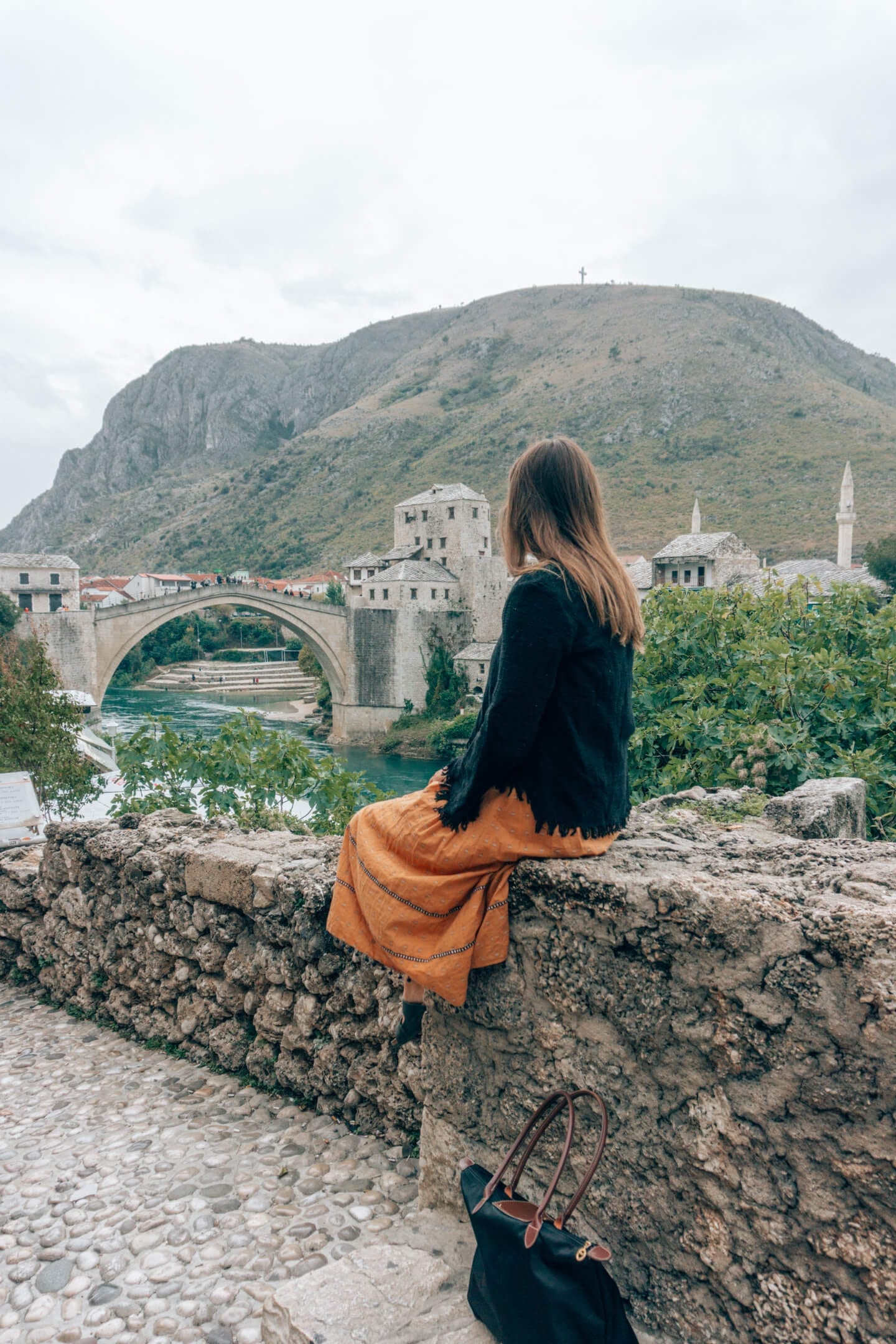 Brunette girl looking down at the Stari Most Bridge