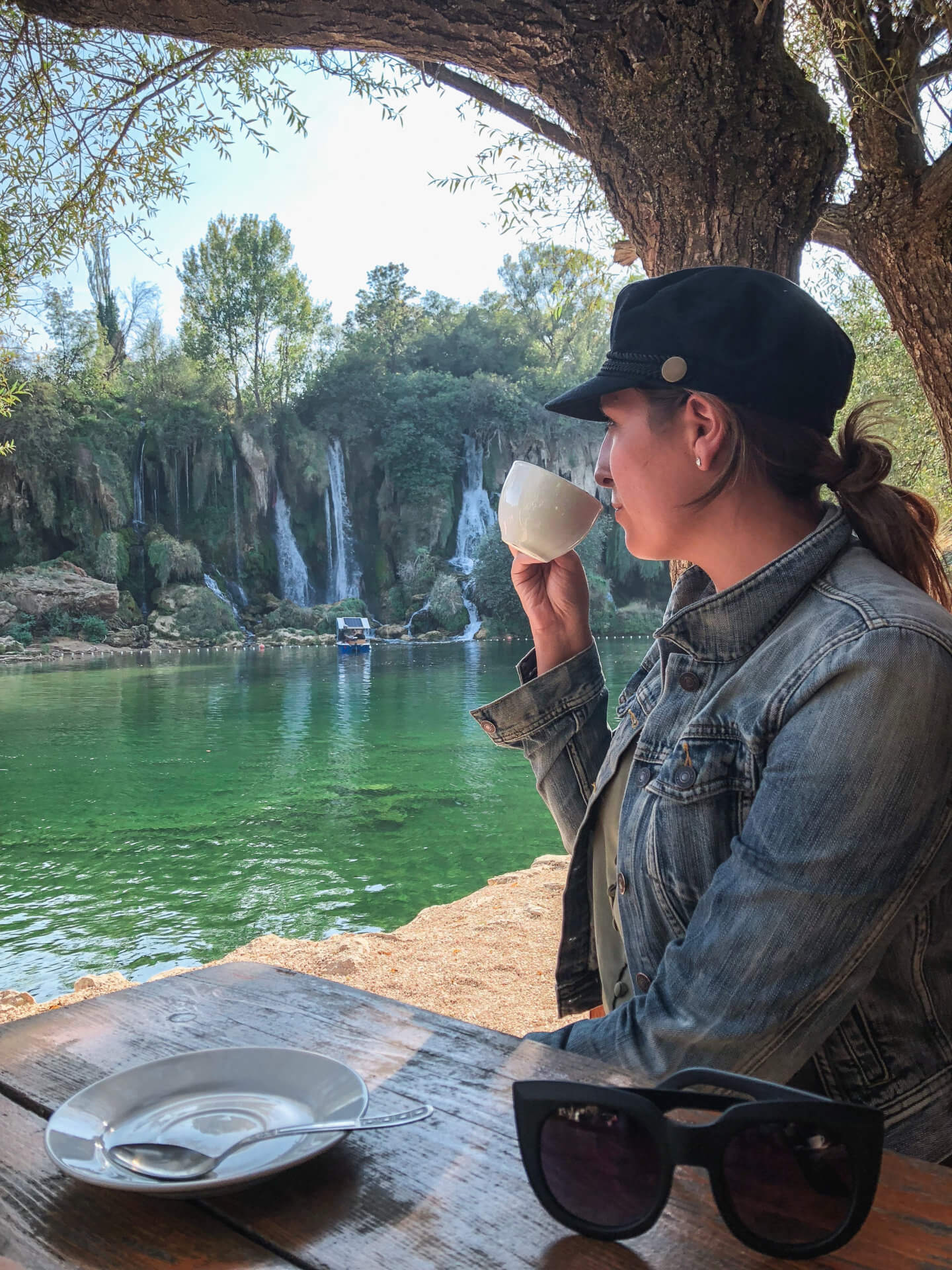 Girl sipping coffee in front of theKravica Waterfall