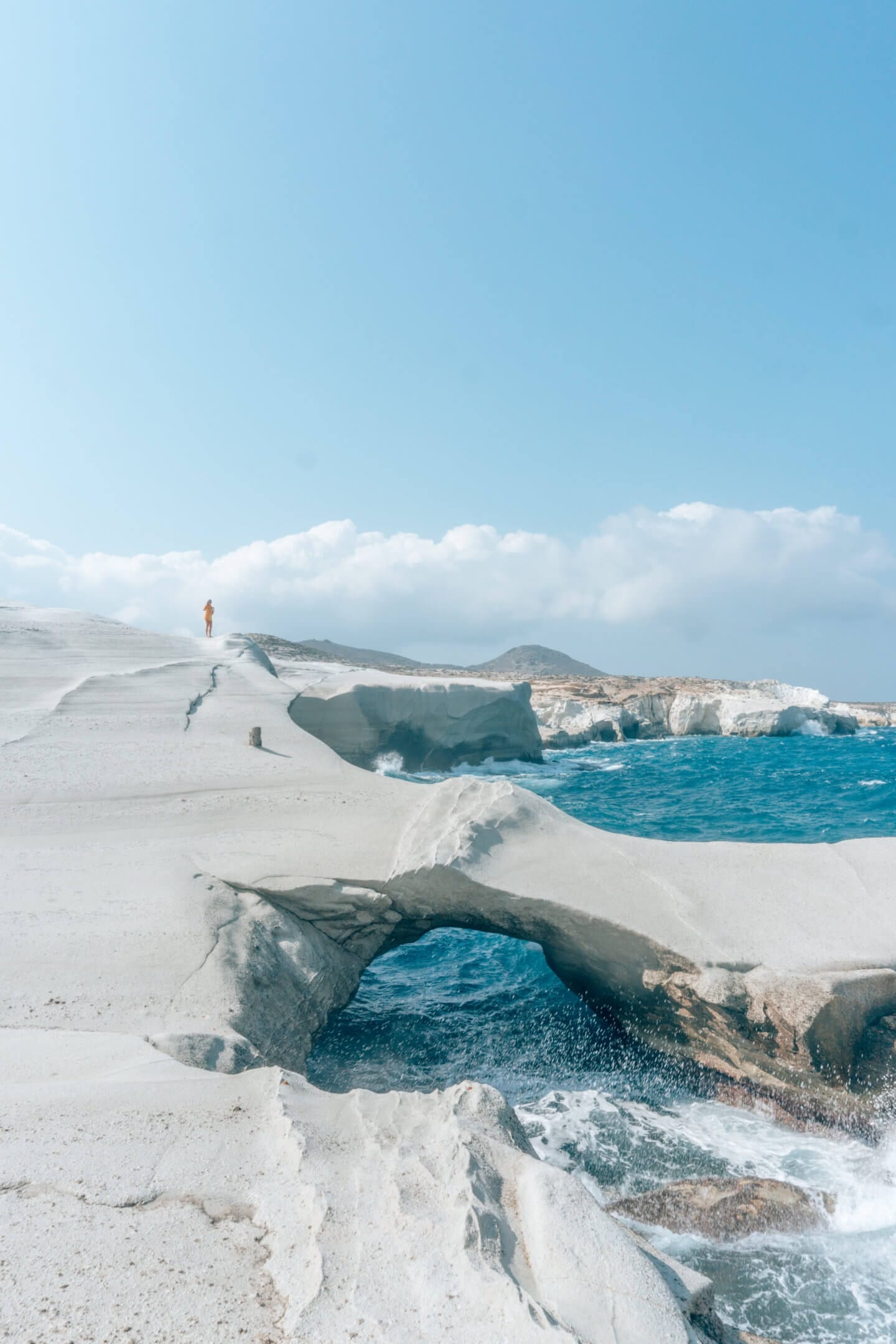 Girl standing on top of Sarakiniko - a must see beach on this Milos Travel Guide