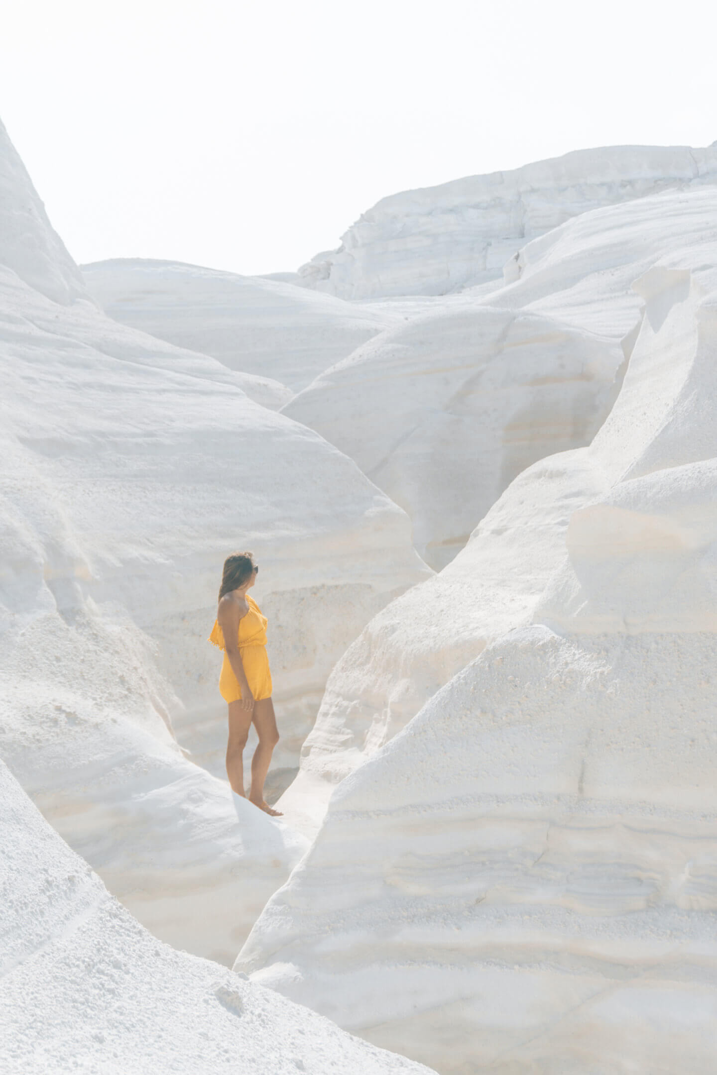 Girl standing amongst the white stone of Sarakiniko - Milos travel guide