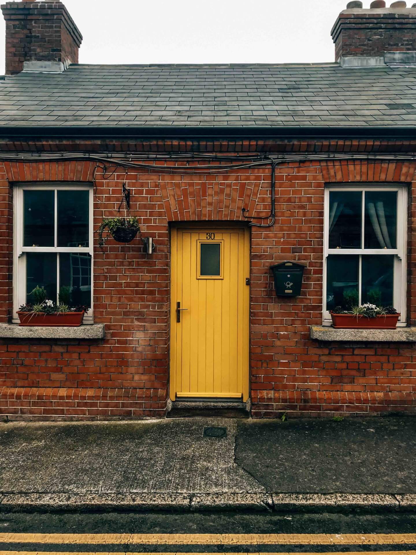 Cute yellow door on a brick cottage in Dublin, Ireland