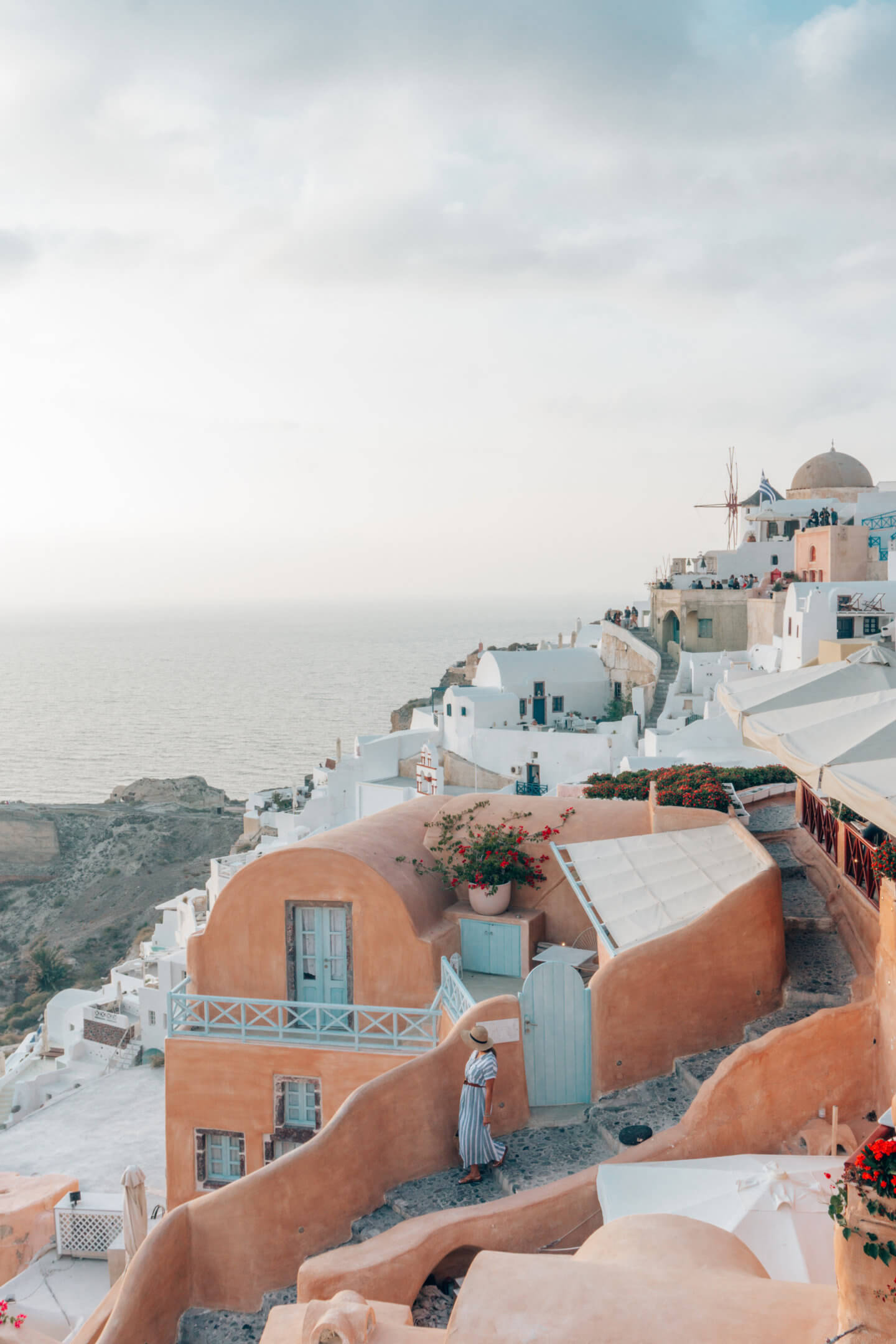 A girl walks in beautiful Santorini, one of the most romantic places in the world. 