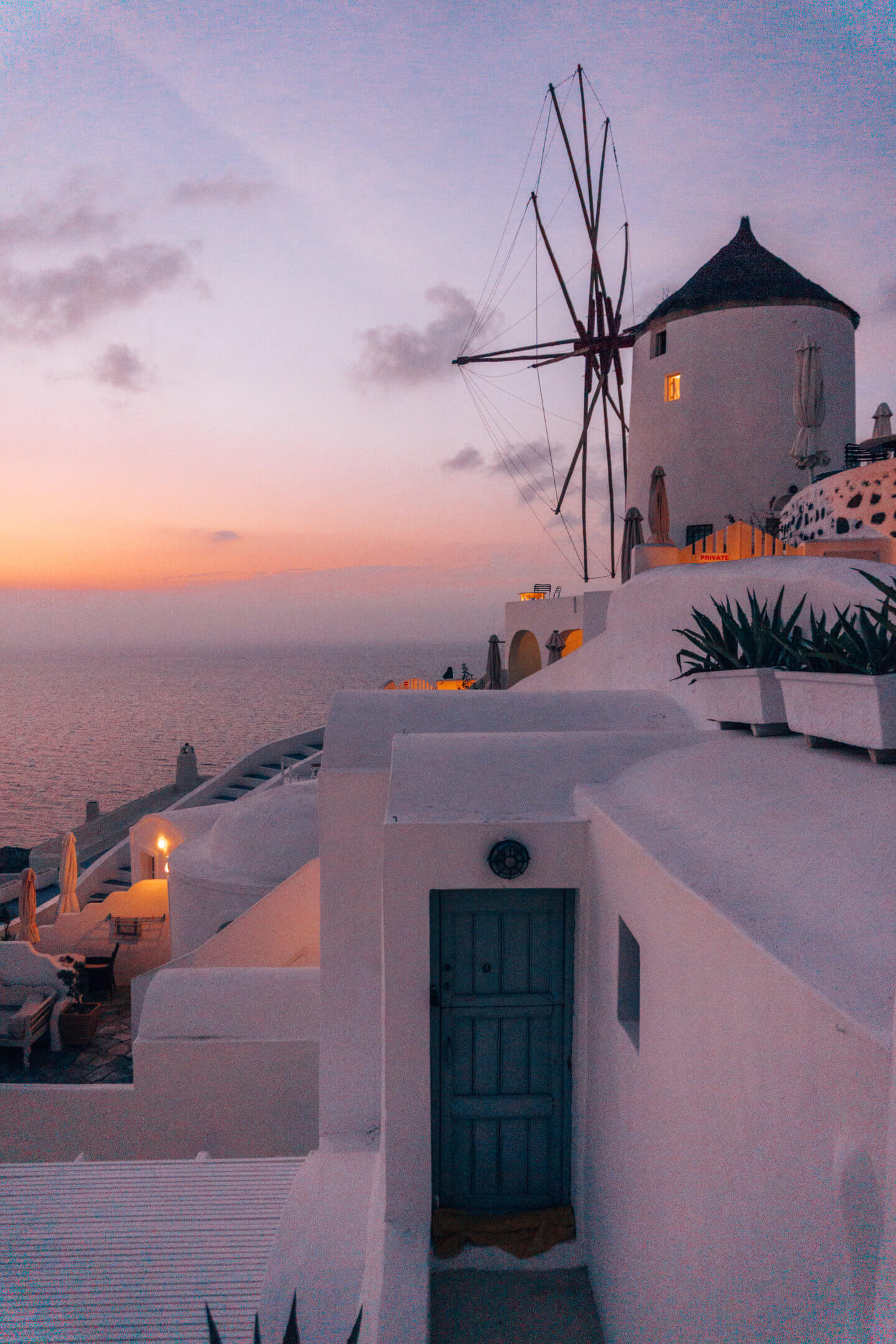 A historic windmill on Santorini during a beautiful sunset in Greece.