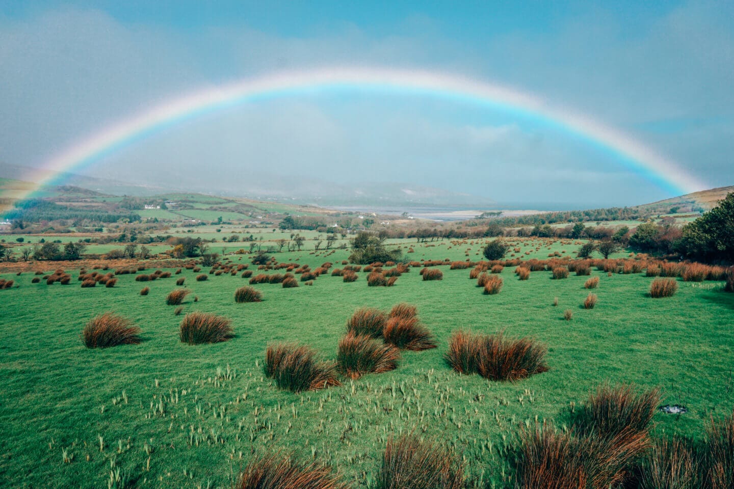 Beautiful rainbow over a green field in Ireland