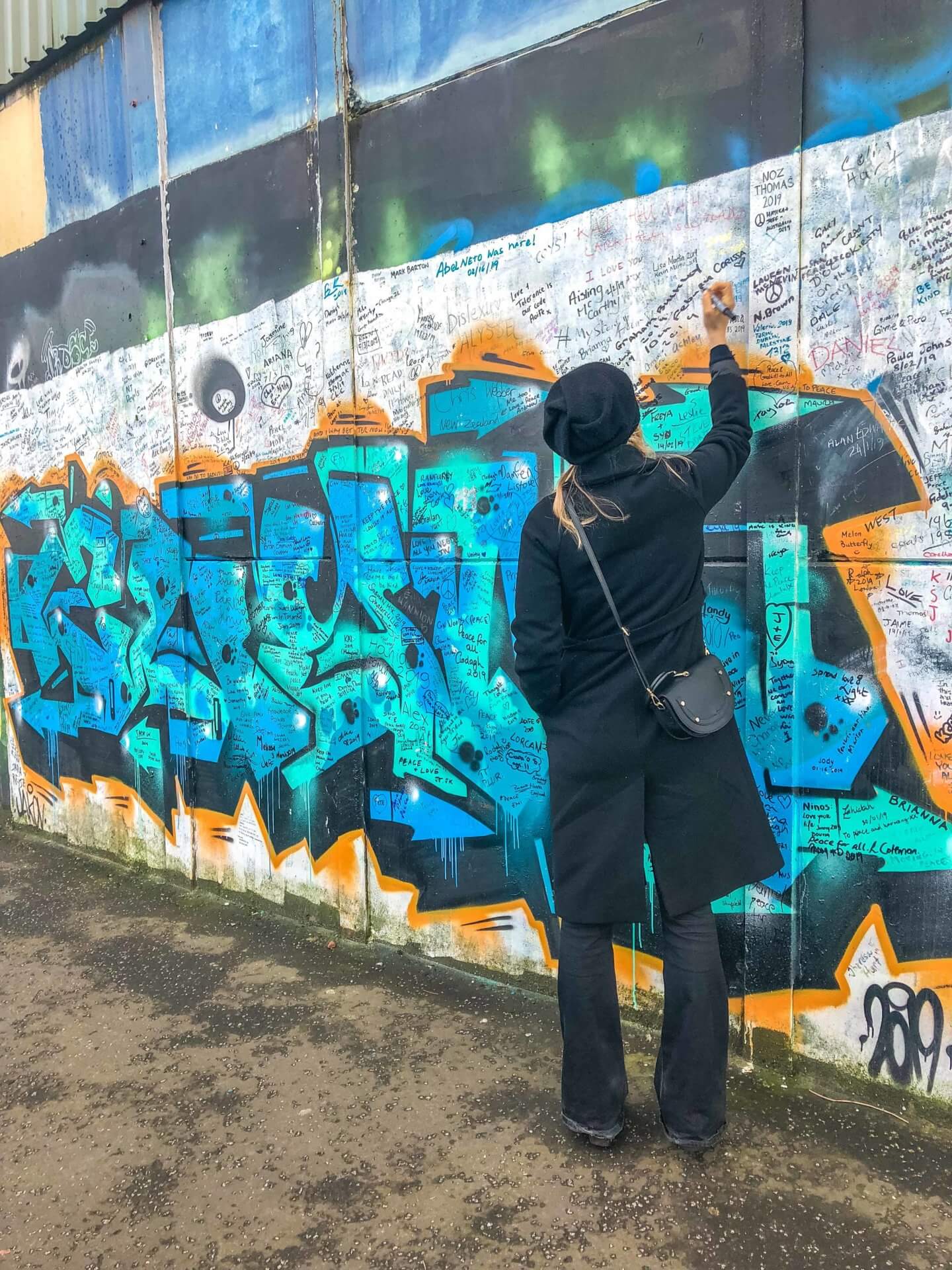 Girl signing the Peace line in Belfast, Northern Ireland 