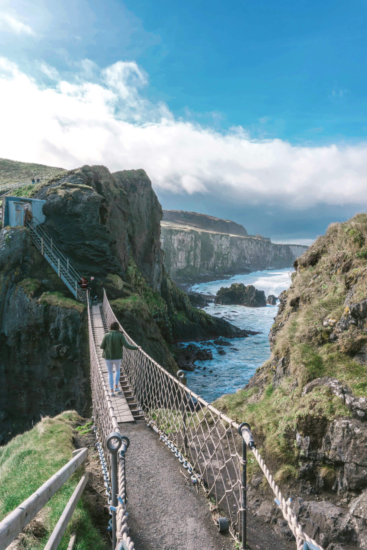 A Girl crosses the National Trust Carrick-a-Rede Rope Bridge - places to visit in Ireland