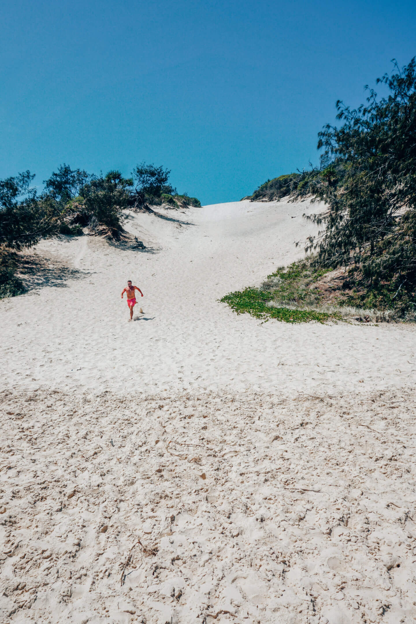A man running down a sand dune