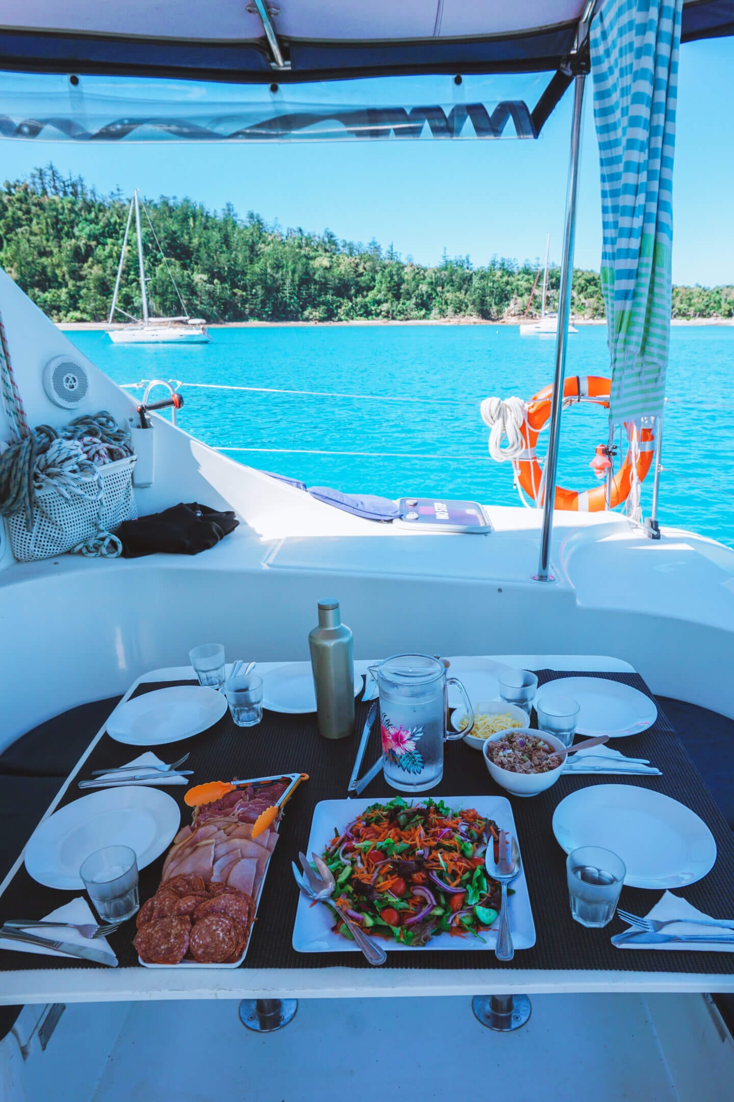 Salad and meats on a set table on a sailing boat on the Whitsundays