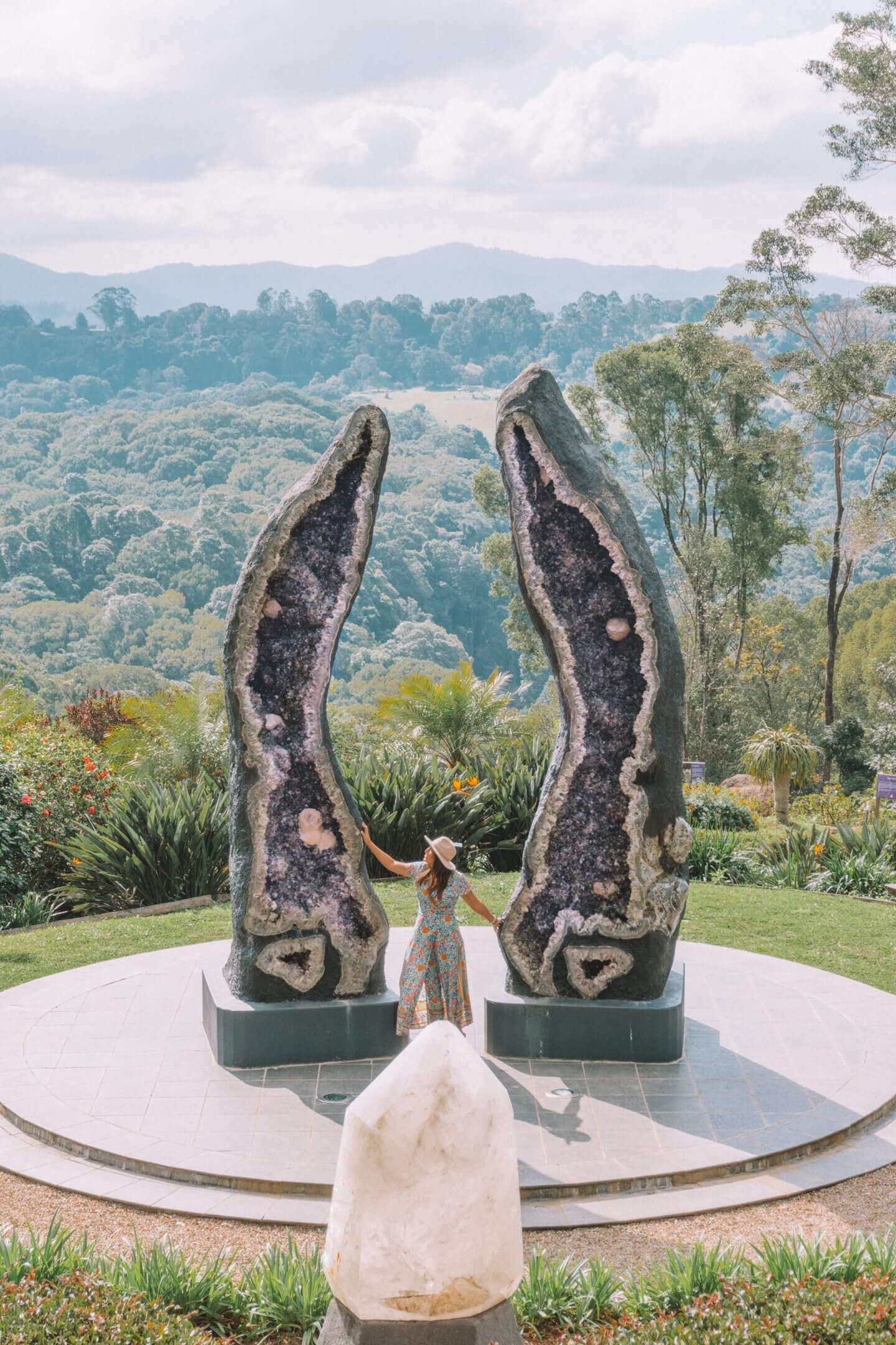 Girl in a hat looking up at the two largest amethyst geodes in the world at Crystal Castle in Mullmbimby NSW