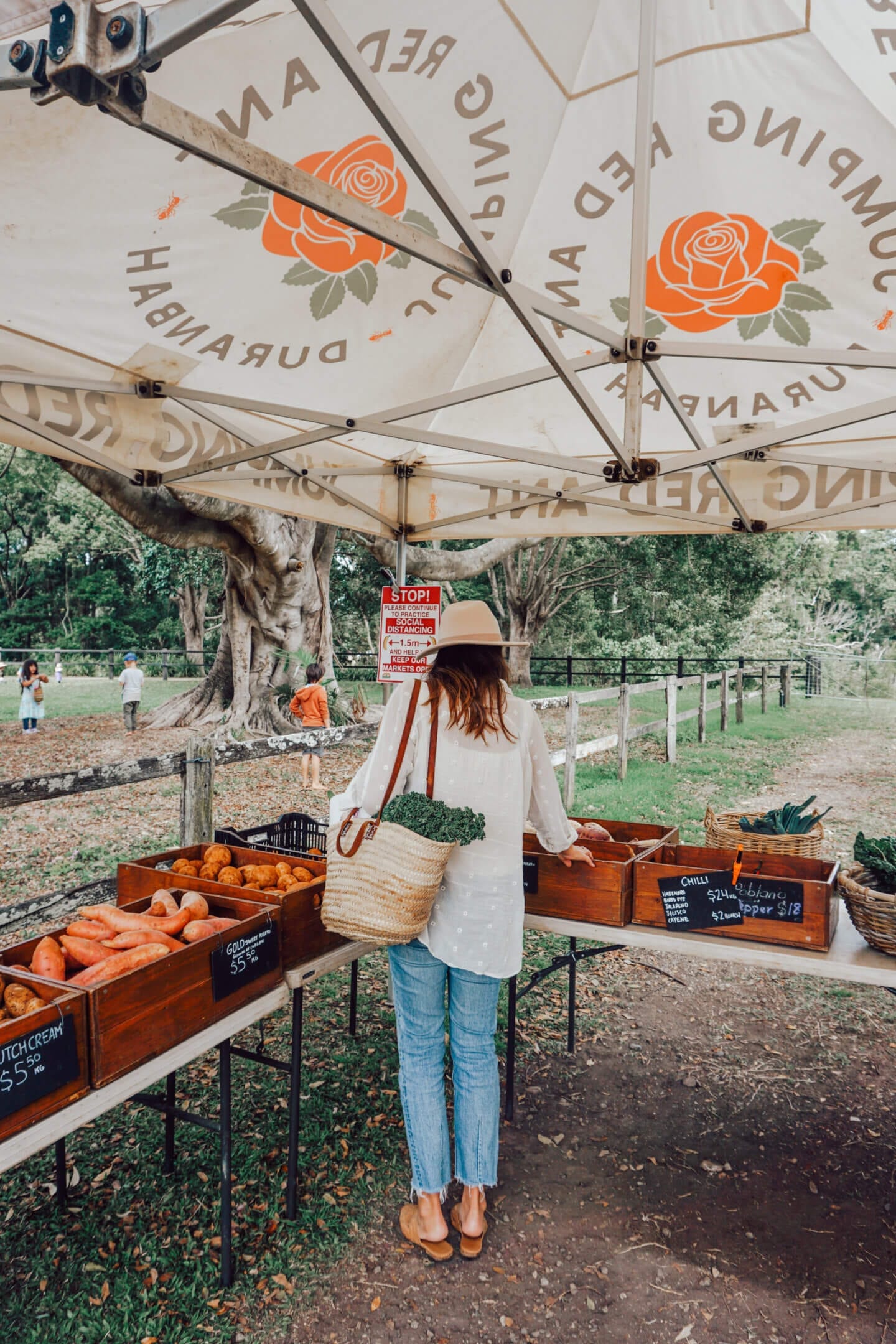 A girl picks vegetable at the Mullumbimby Farmers Market outside of Byron Bay, Australia.