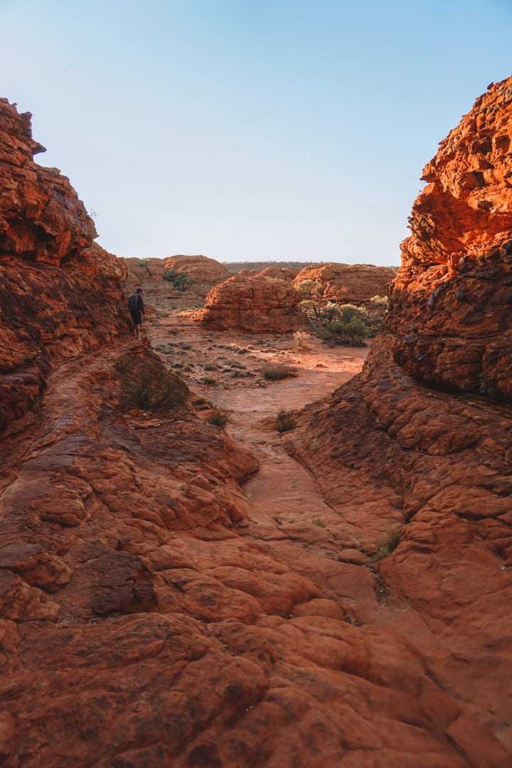 A man sits on the red walls of Kings Canyon