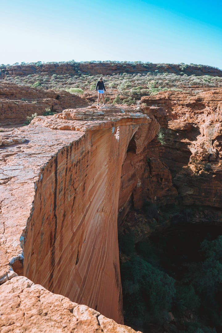 Girl stands on the edge on Kings Canyon in the morning 