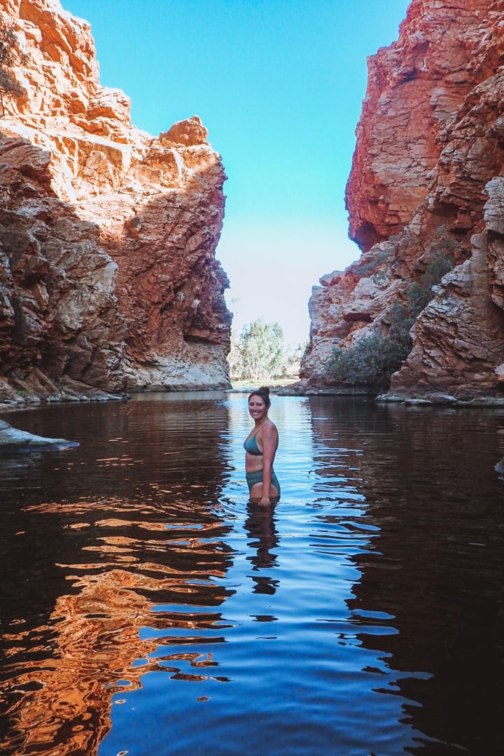 Girl in a green bikini standing in Ellery Creek Big Hole in West Macdonnell Ranges