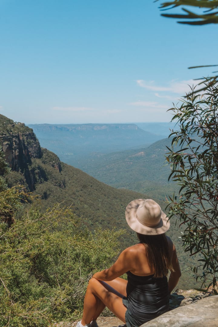 A girl with a hat on looking out the expansive views in the Blue Mountains Australia