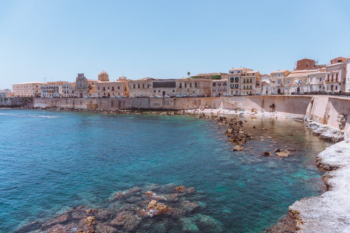 A Mediterranean beach in front of Ortigia Sicily, one of the most romantic places in Europe for a Unique Honeymoon