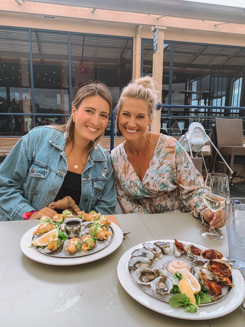 Two girls with plates full of oysters at the Marina Hotel Pub in Port Lincoln