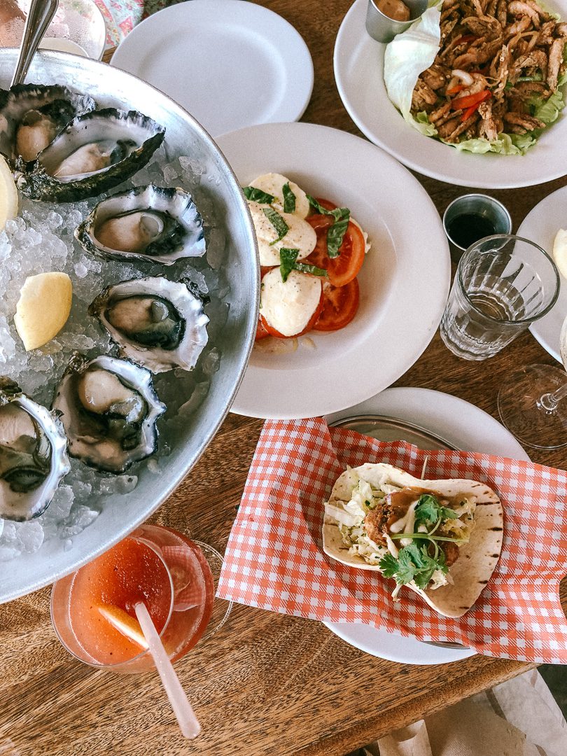 A platter of a dozen oysters, caprese tomatoe salad, and tacos at The Balcony restaurant in Byron Bay