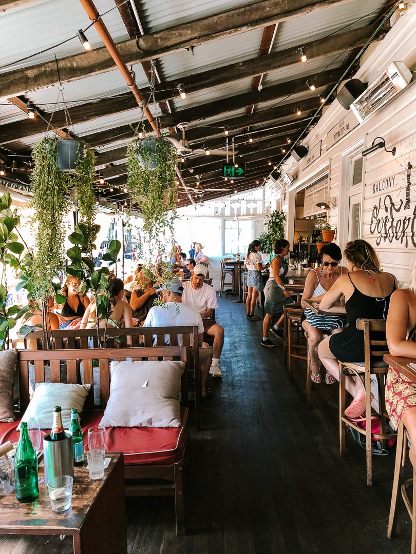 The busy side patio with hanging plant baskets at The Balcony Restaurant in Byron Bay