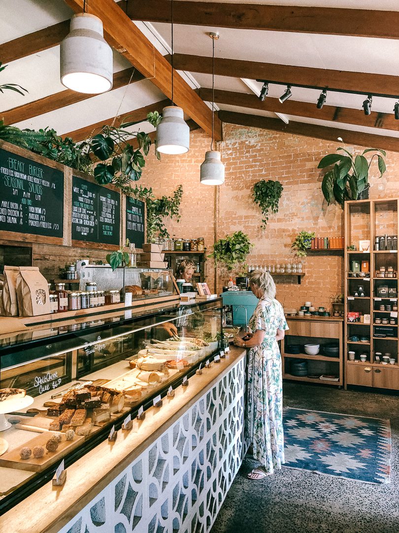 A women looks at a counter of freshly baked goods at Bayleaf cafe in Byron Bay