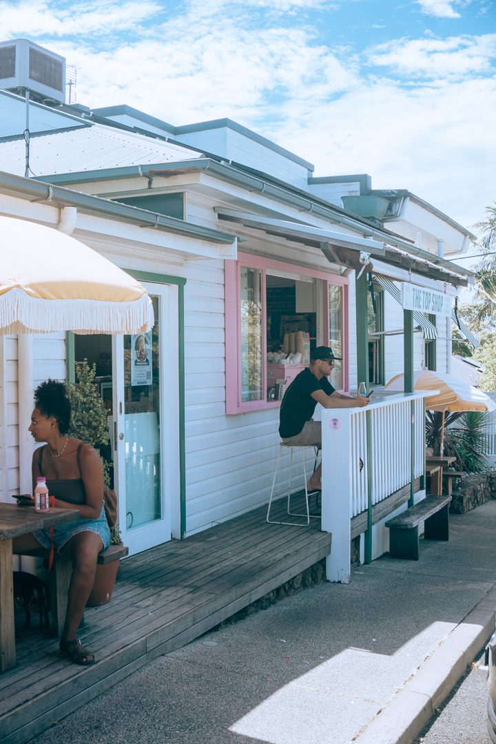 A guy sitting near a pink window at the Top Shop cafe in Byron Bay