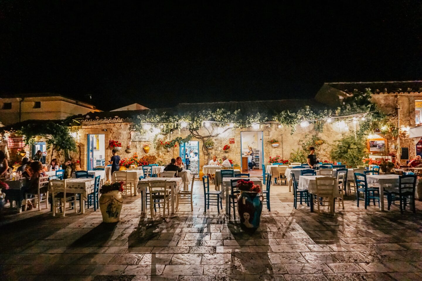 A greek looking restaurant at night time in Sicily
