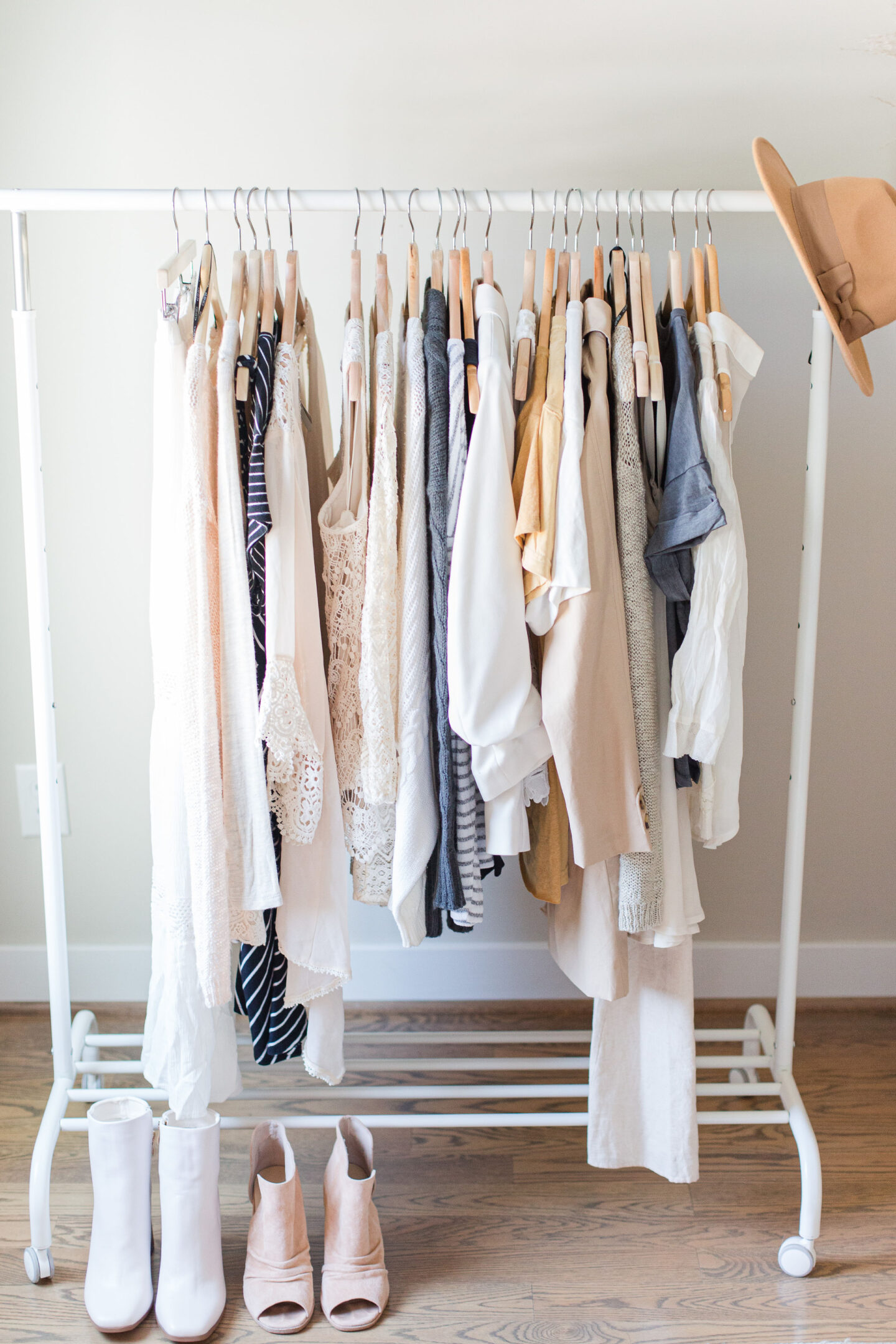 Travel packing tips: A white rolling rack of women's clothes.