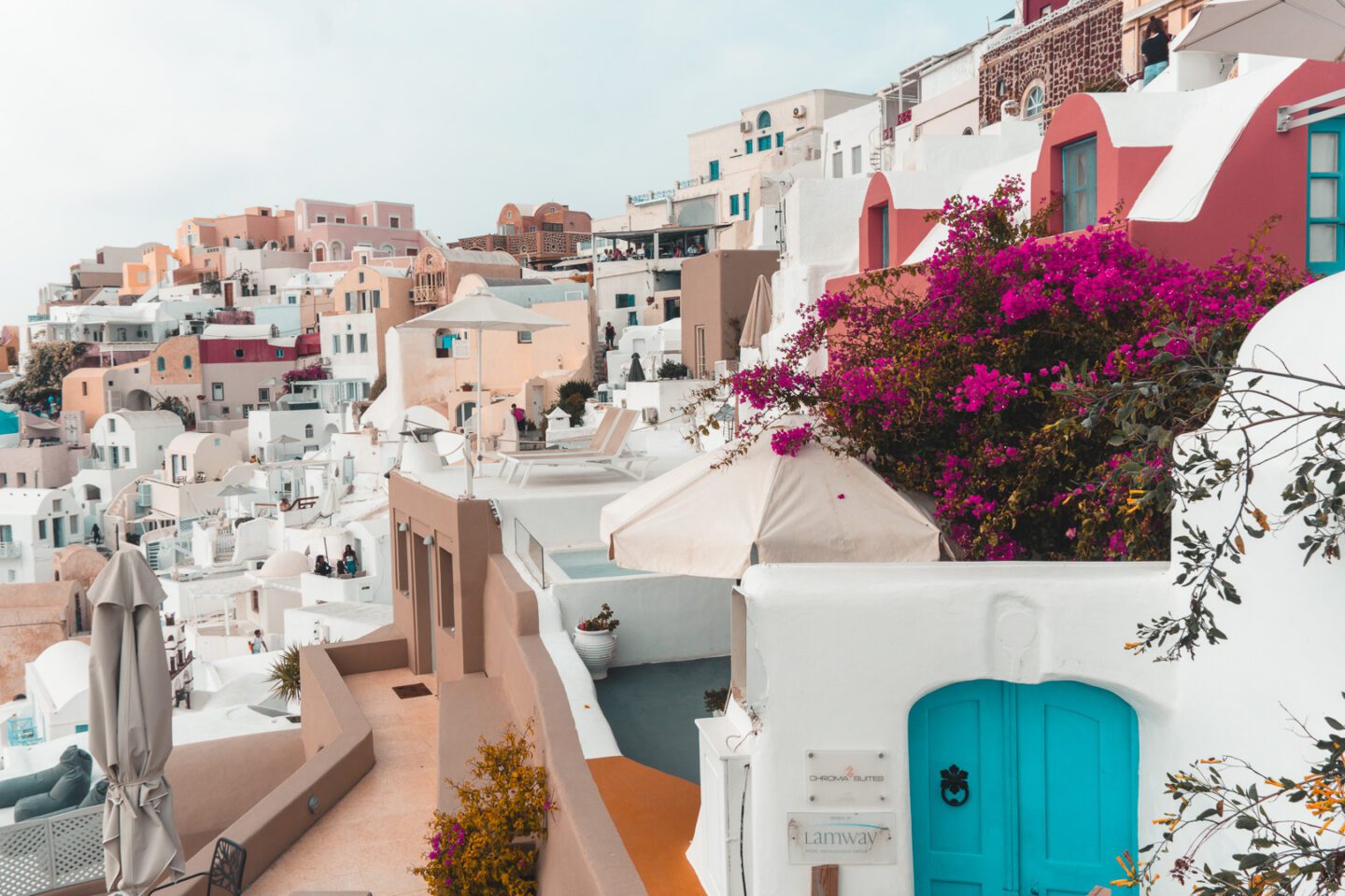 Santorini is a must-see during your 10 Days in Greece Itinerary. Here you will see white washed buildings, blue doors, and flowering bougainvillea.