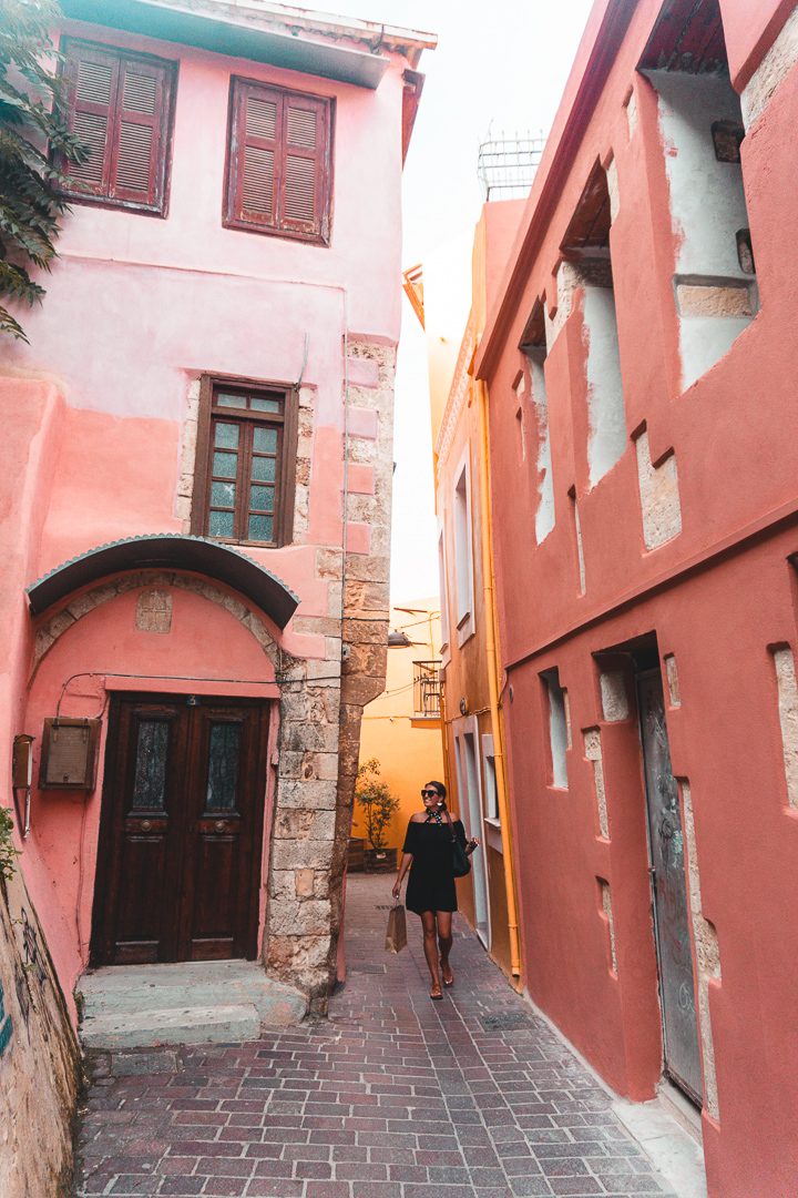 A girl walks through the colourful apartment buildings in the old town of Chania, Crete. 