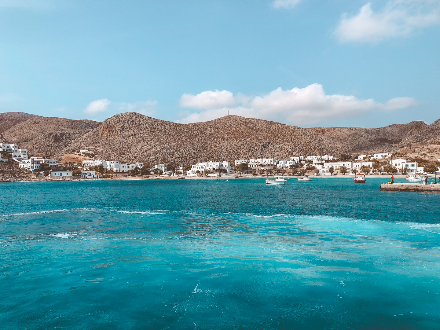 Sailing away from the Greek Island of Naxos on a speed ferry and admiring all the boats and white houses along the cliffs. 