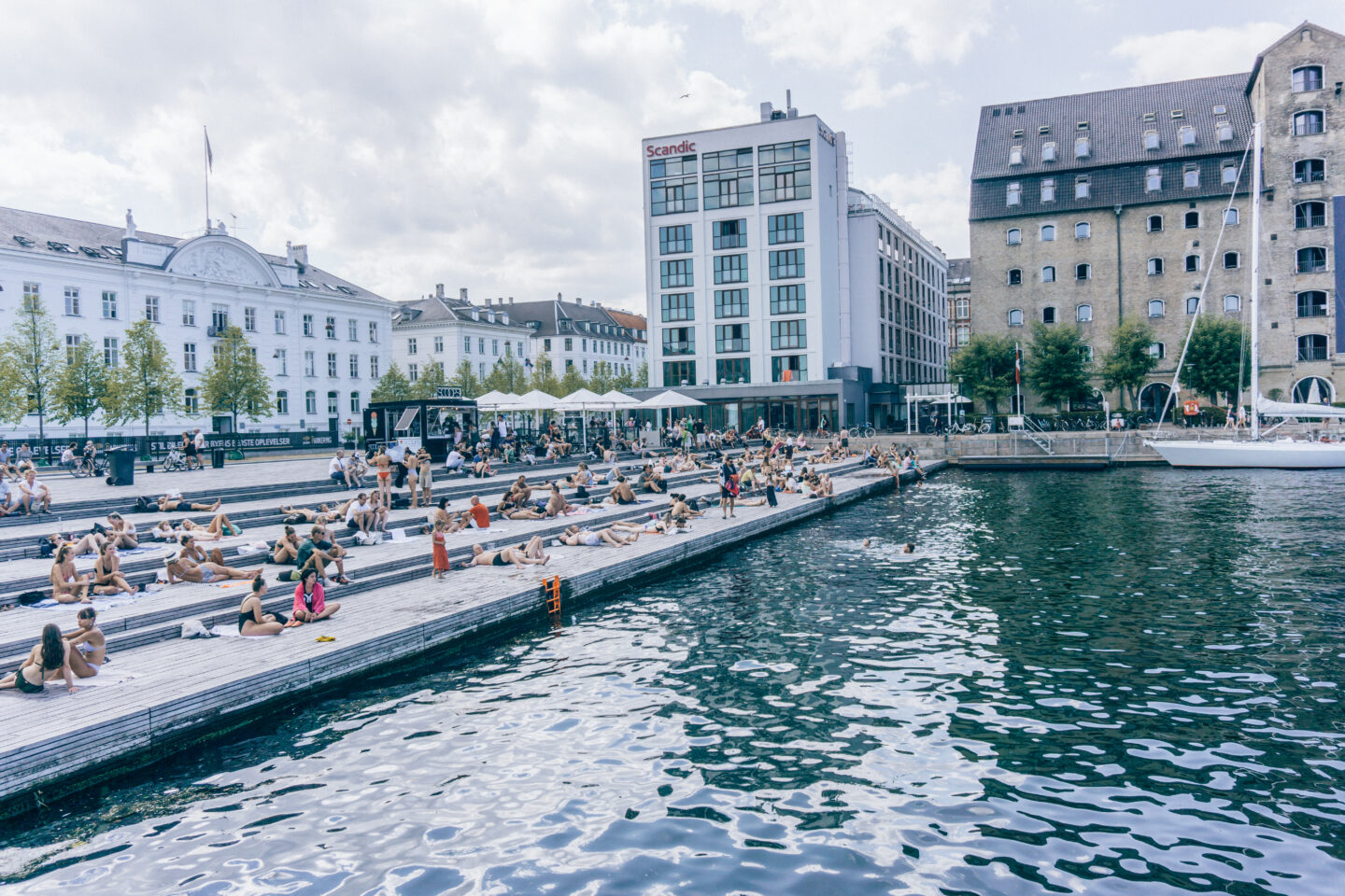 People swimming and sunbathing at the canals in the heart of Copenhagen 