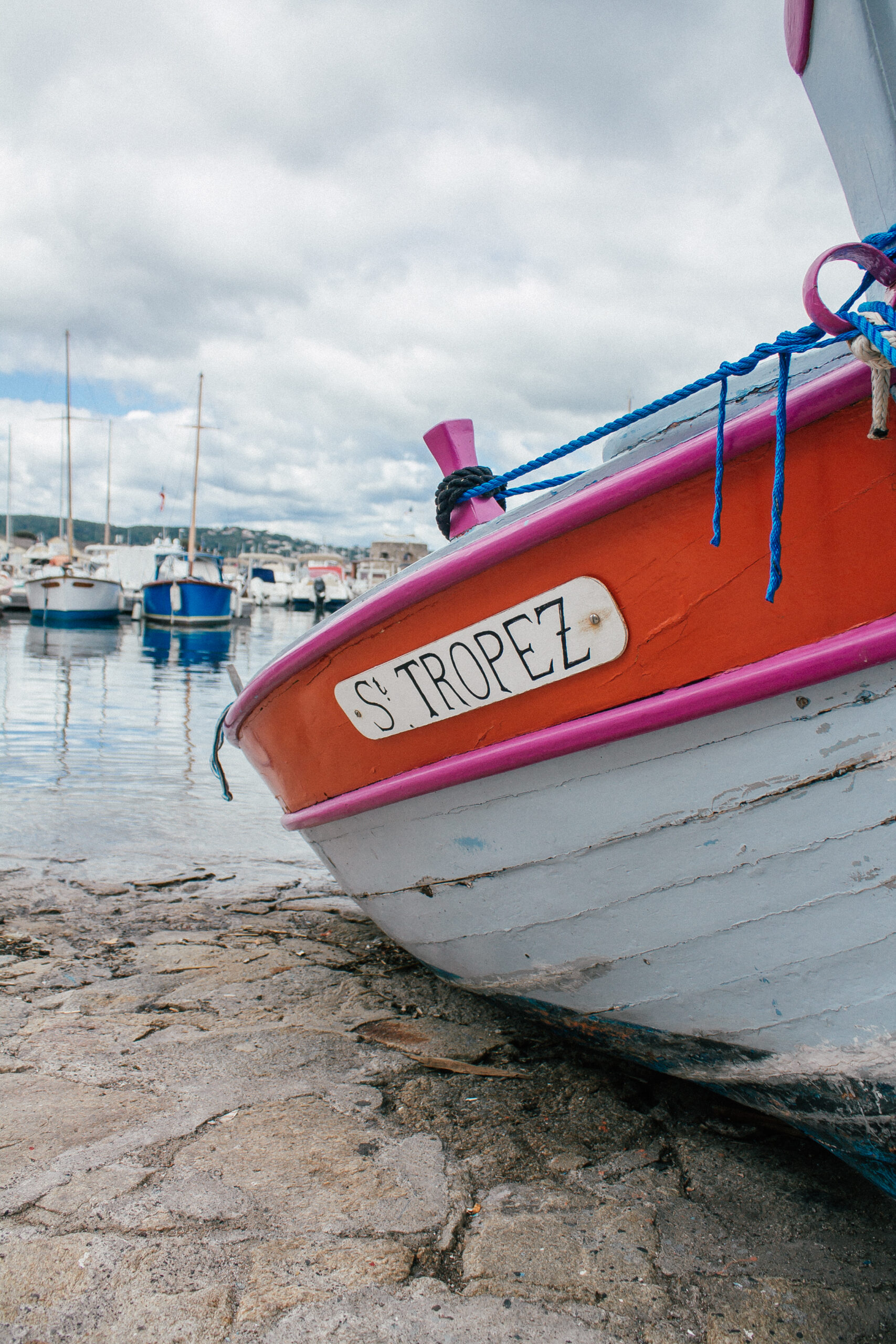 A red and white row boat with the name St Tropez beached up in the Marina of Saint Tropez, France