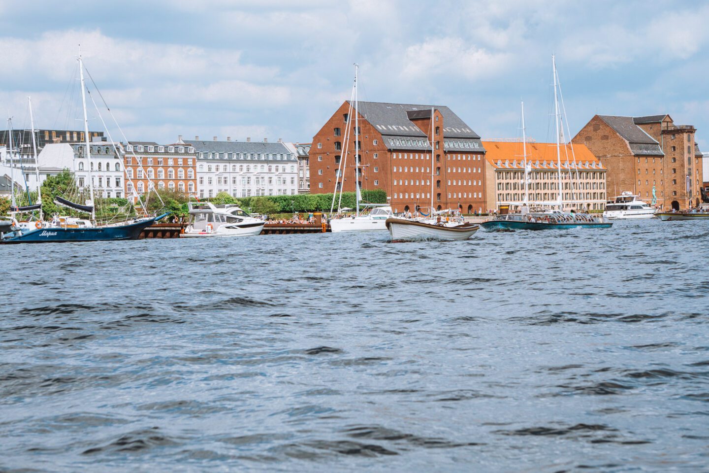 The Copenhagen skyline and boats in the canals, including one of the long canal boat tours that is a top thing to do in Copenhagen