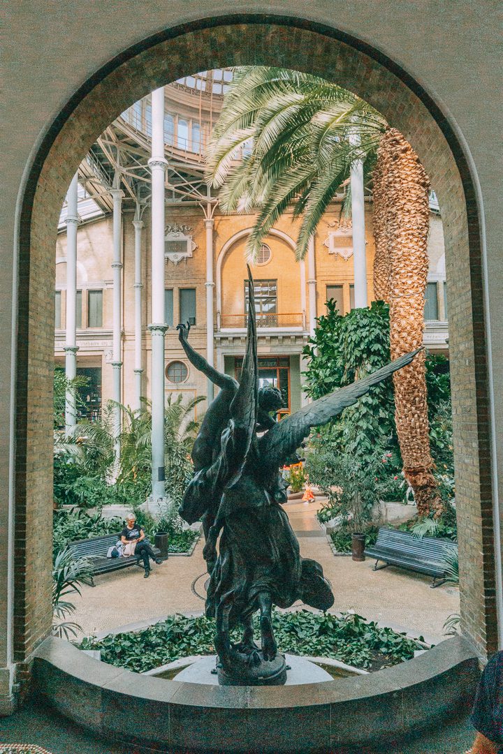 A marble statue of an angel in an arched entranceway in Ny Carlsberg Glyptotek Museum, which is included in the Copenhagen Card