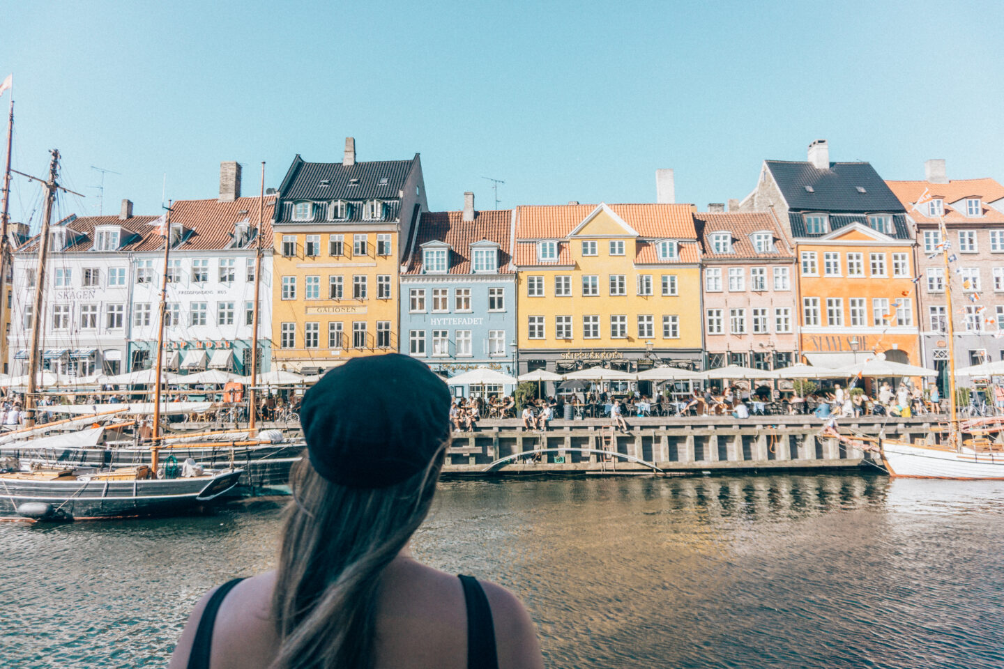 A budget-conscious female traveller looks out at Nyhavn, and is greatful she bought the Copenhagen Card that has saved her hundreds of dollars on her trip!