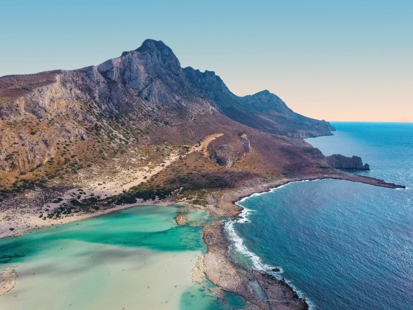 An aerial shot of Balos Beach showcasing the beautiful blue waters, and high mountains on this Greek Island. This beach is one of the top things to do in Crete.