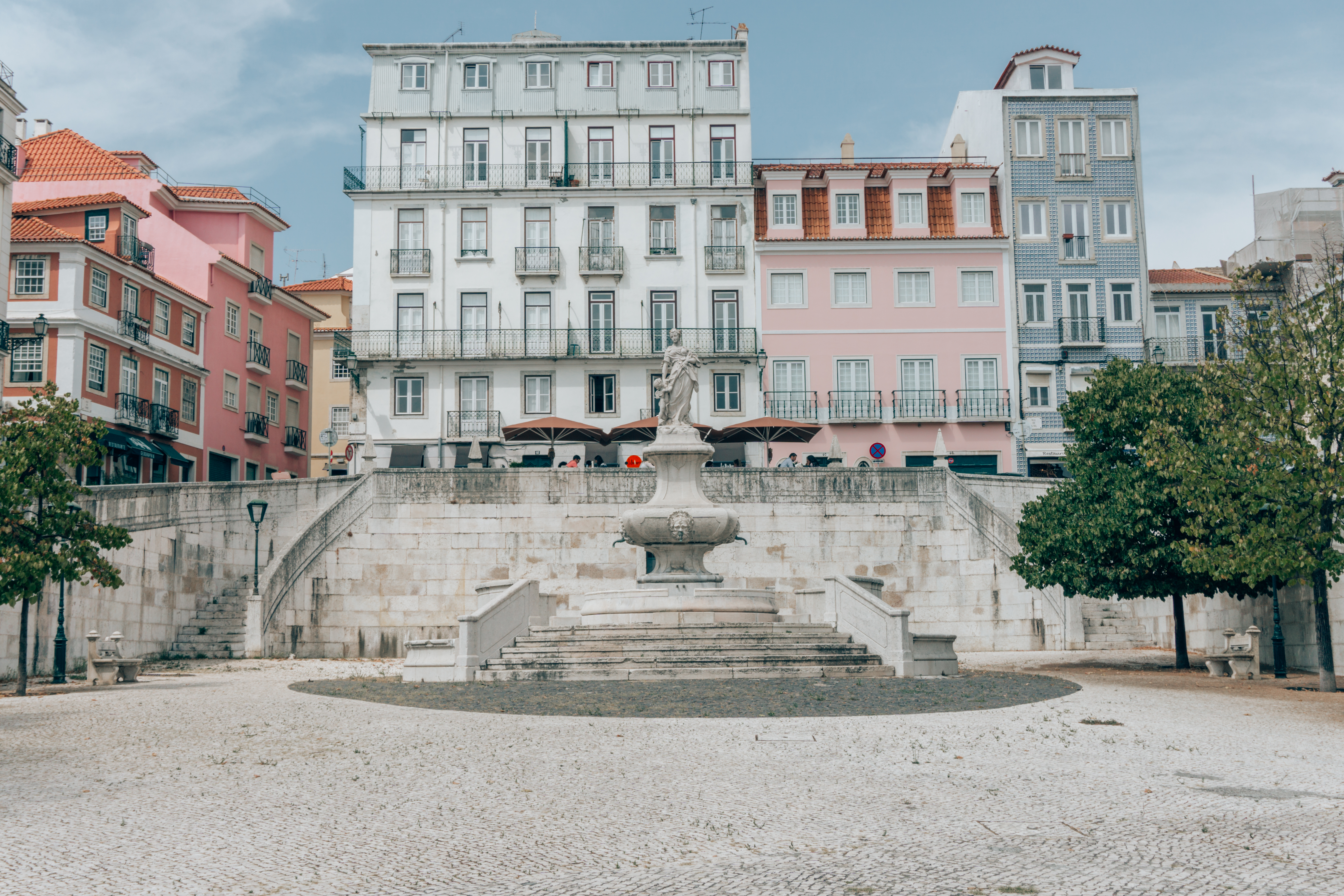 Colourful apartment buildings and a stunning fountain in Lisbon Portugal. 