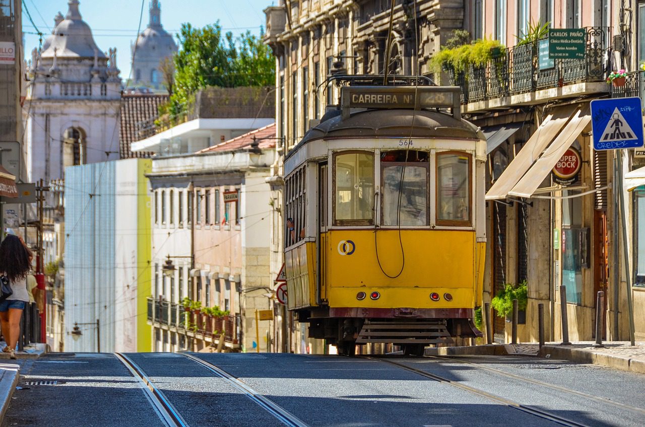 A yellow tram moving through the colourful streets during 3 days in Lisbon Itinerary