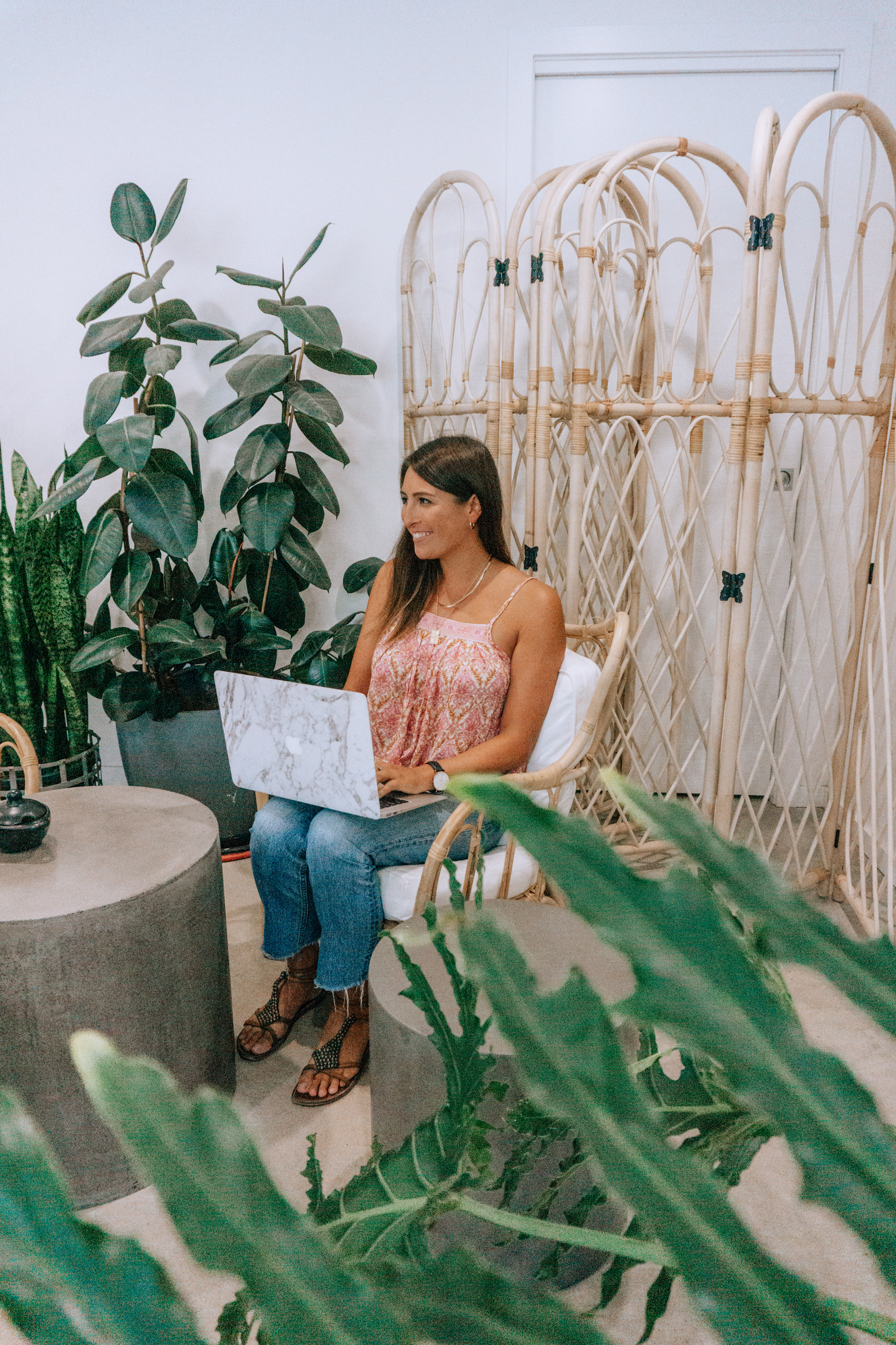 A girl on her laptop smiling because she is using my Travel Planning Resources & Travel Gear I Swear By