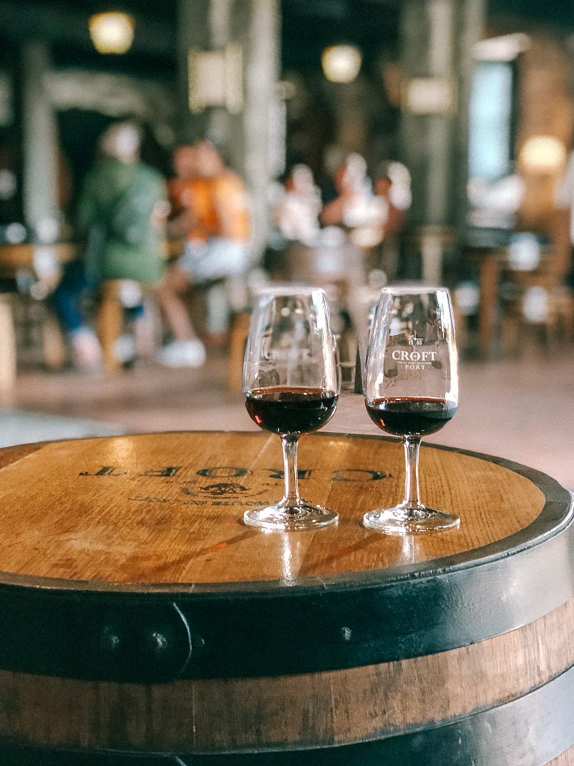 Two glasses of red port in Croft classes and on top of croft barrals in the cellar in Porto