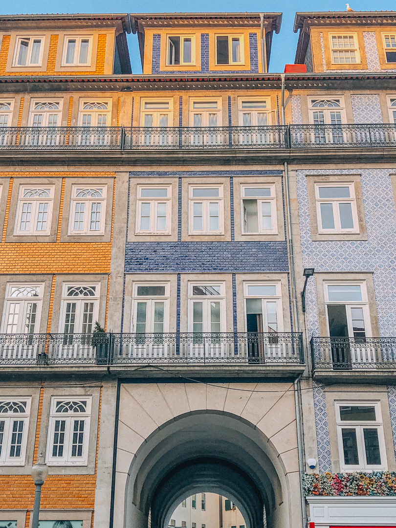 The golden glow of sunset on 3 colourful, traditional tiled buildings in Bolhão and Cedofeita Districts in Porto.