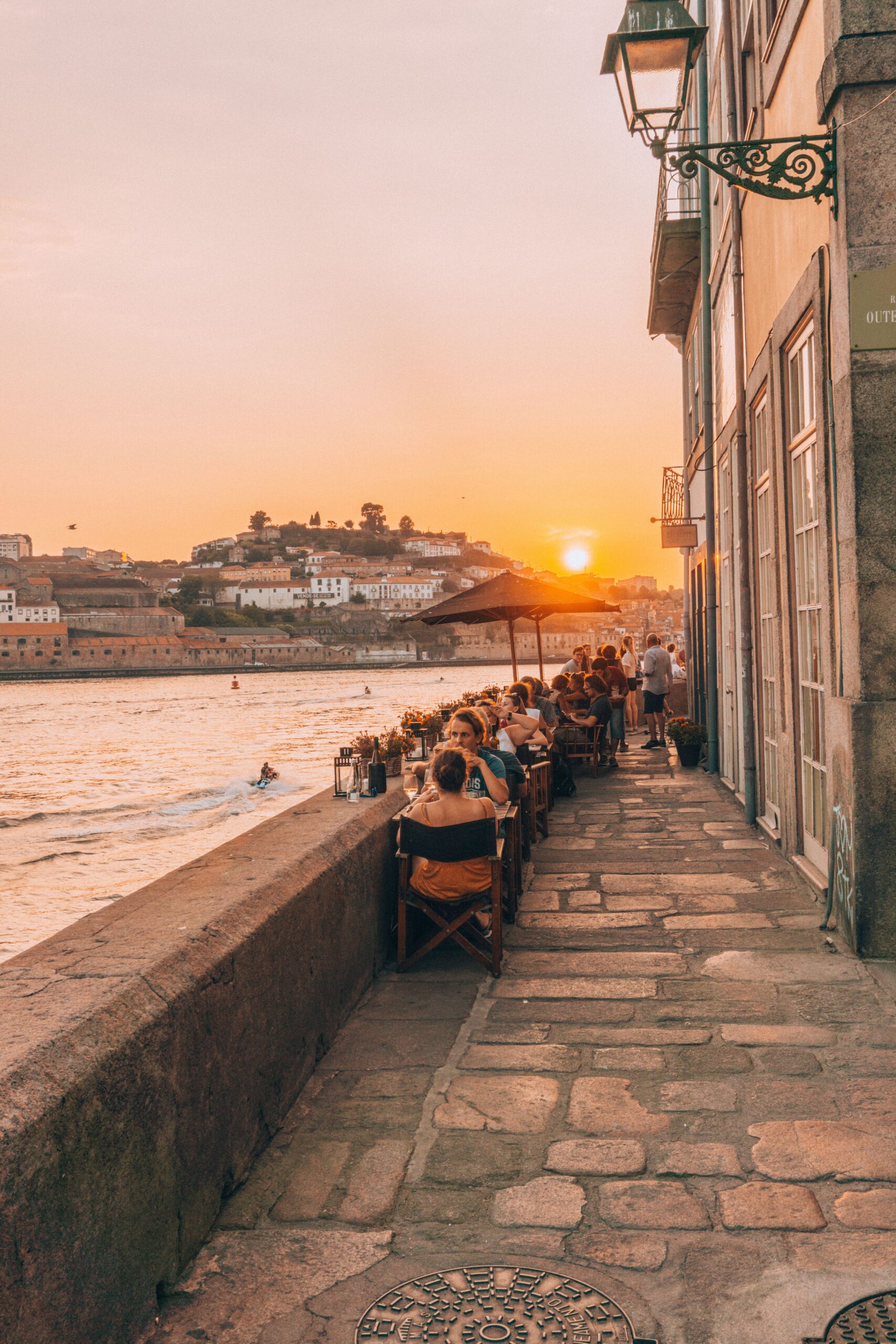 The golden glow of sunset at Bacalhau Restaurant beside the Douro River, in Porto, Portugal