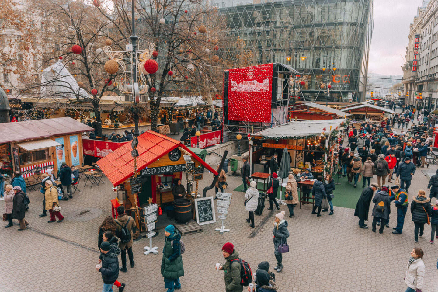 Looking down at the bustling Vörösmarty Square Christmas Market stalls and decorations.