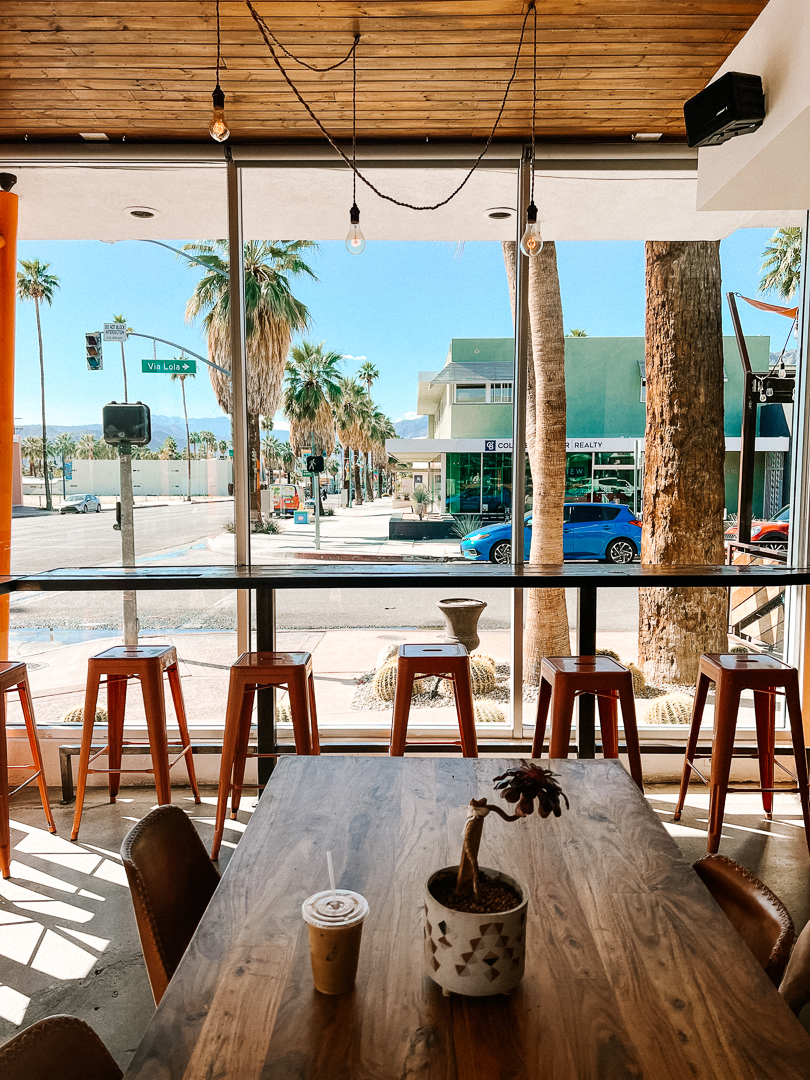 Inside Ernest Coffee Cafe looking out to the palm tree lined streets of Palm Springs, California