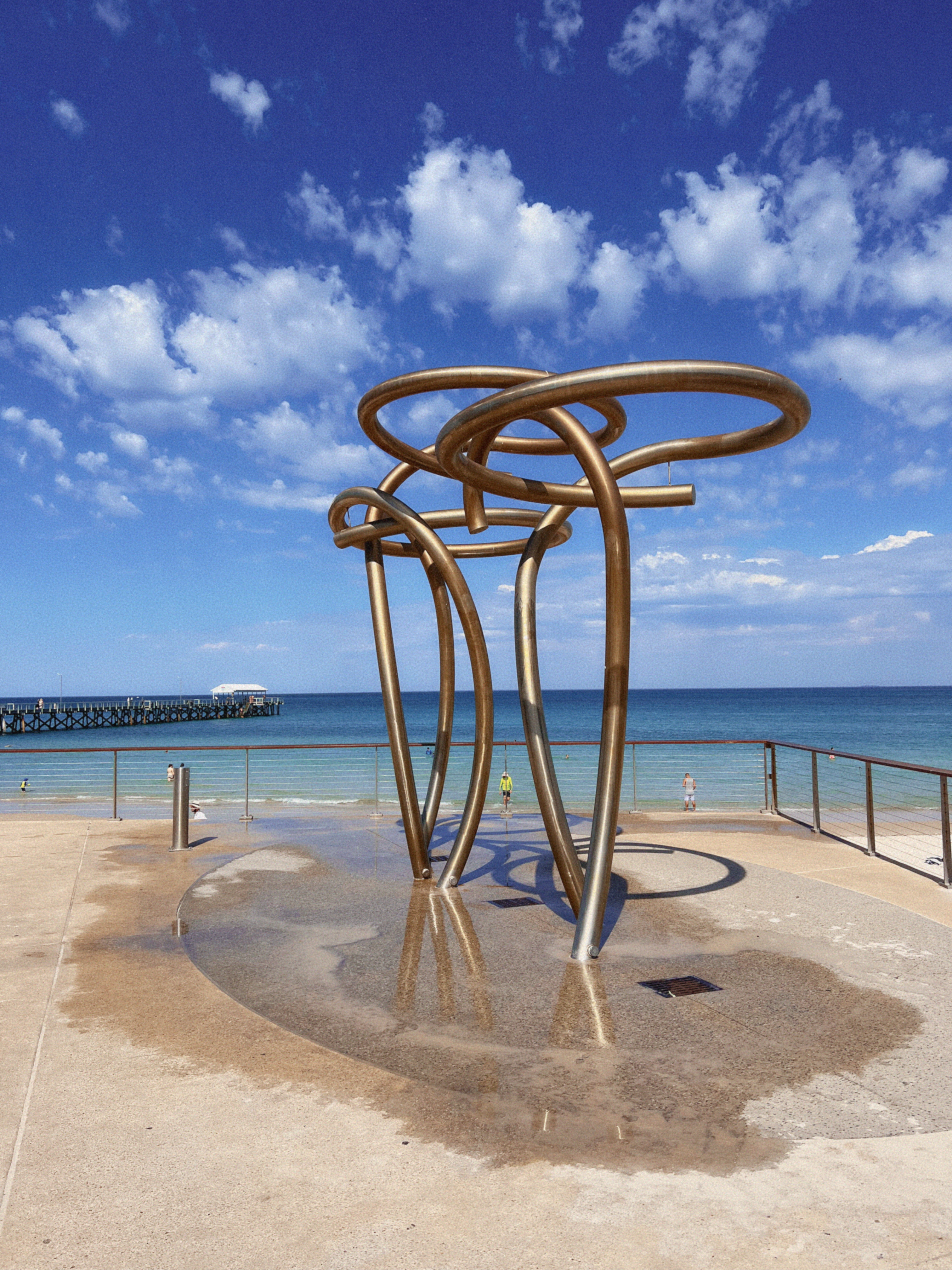 An interesting art sculpture that doubles as showeres in front of the ocean at Glenelg Beach in Adelaide – free fun things to do in Adelaide